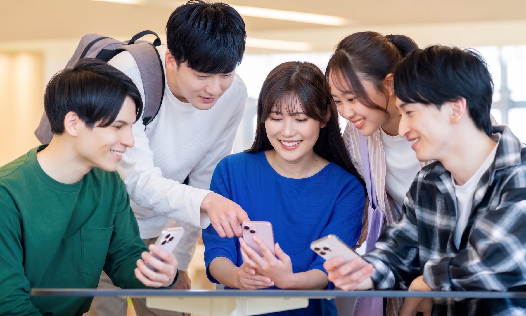 スマートフォンで企業のSNSを見る就活生たち